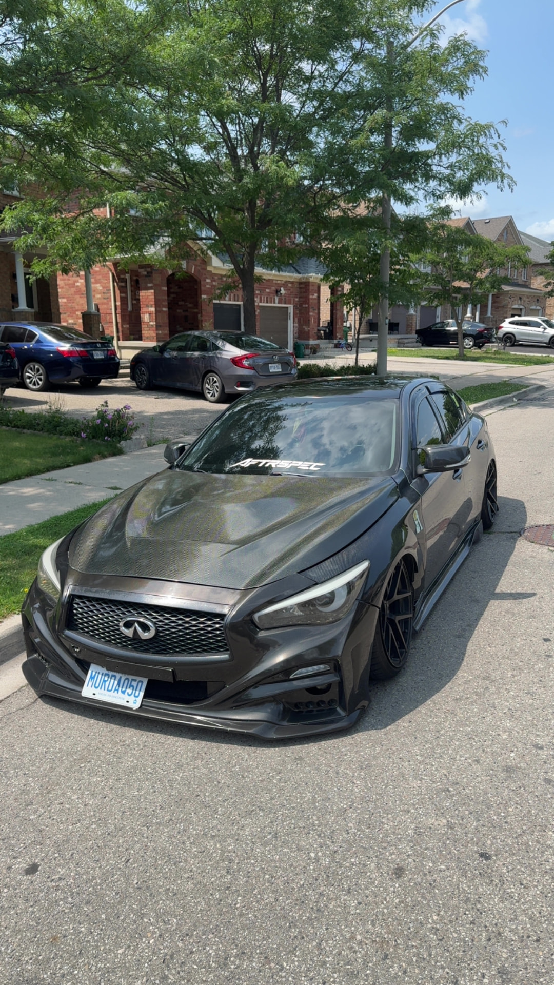 Bagged Infiniti Q50 with carbon hood and AFTRSPEC windshield banner