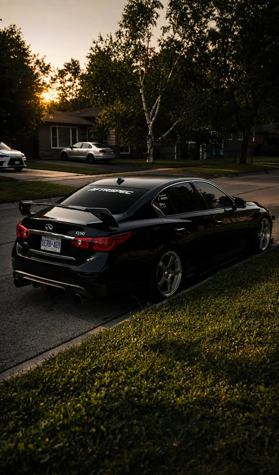 Black Infiniti Q50 at sunset with AFTRSPEC rear-window banner