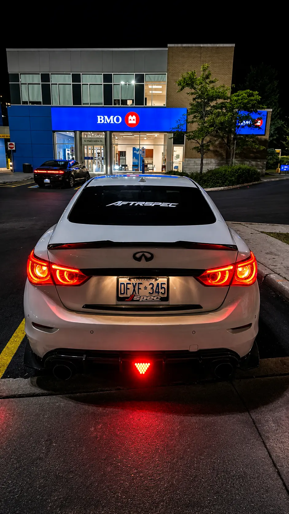 White Infiniti Q50 at night with AFTRSPEC rear-window banner